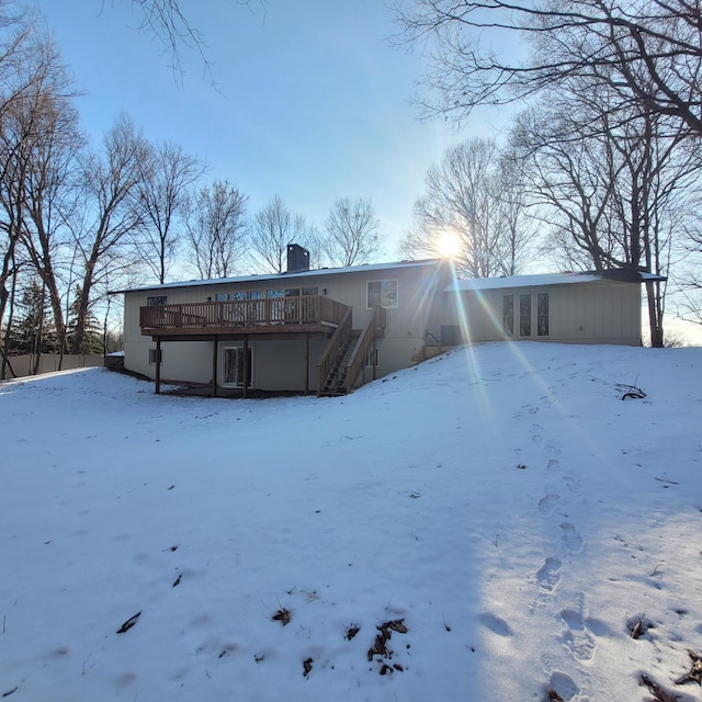 snow covered property featuring a wooden deck