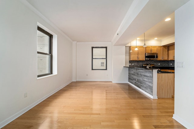 kitchen with crown molding, decorative backsplash, and light wood-type flooring