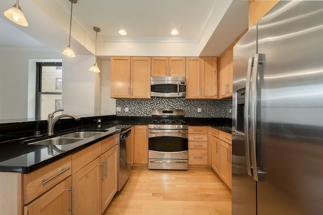 kitchen featuring sink, crown molding, decorative light fixtures, light wood-type flooring, and stainless steel appliances