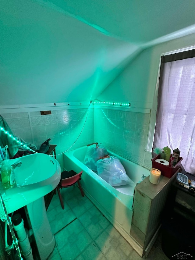 bathroom with a bathing tub and lofted ceiling