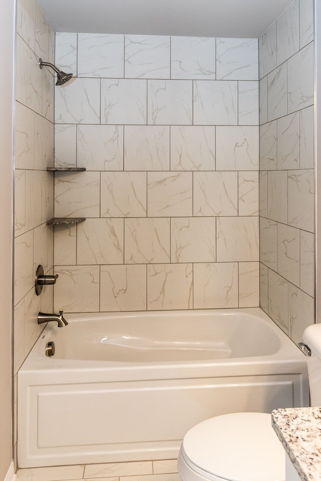 full bathroom with tiled shower / bath, vanity, and toilet