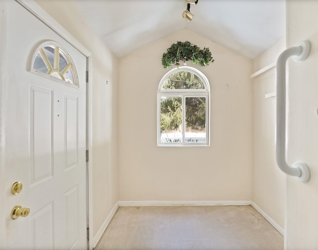 carpeted entryway with lofted ceiling