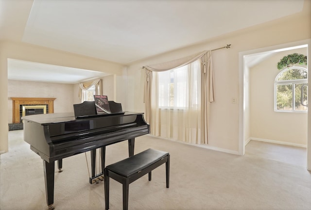 misc room featuring a fireplace, a wealth of natural light, and light colored carpet