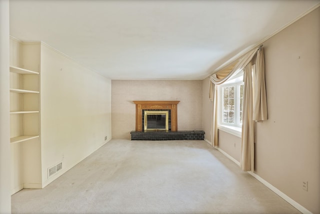 unfurnished living room featuring a brick fireplace, light carpet, and built in shelves