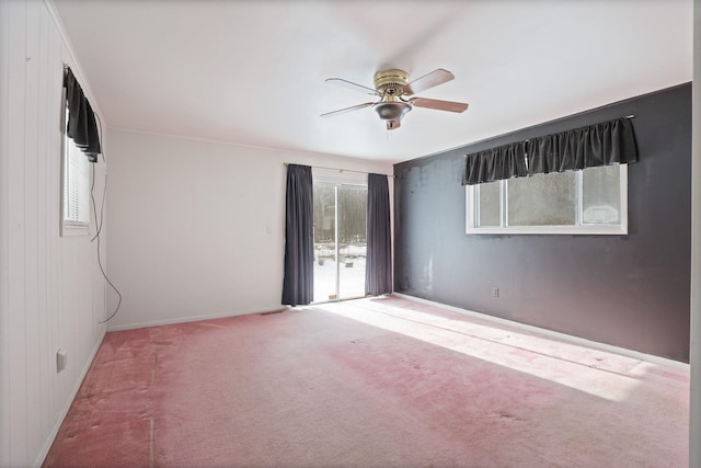 spare room with ceiling fan, carpet, and wooden walls