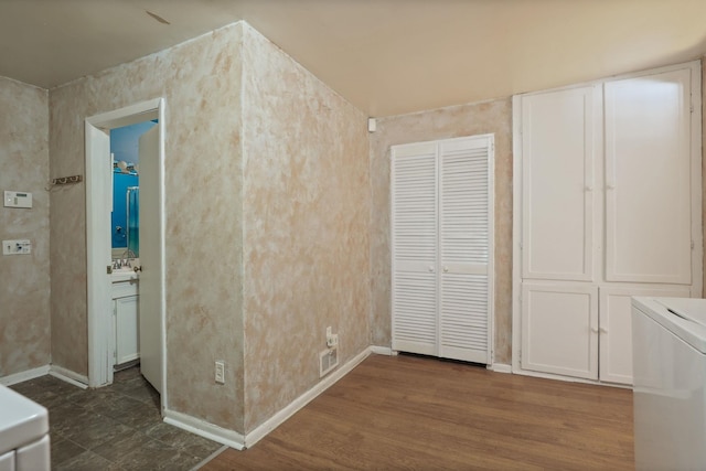 interior space featuring dark wood-type flooring, connected bathroom, washer / clothes dryer, and sink