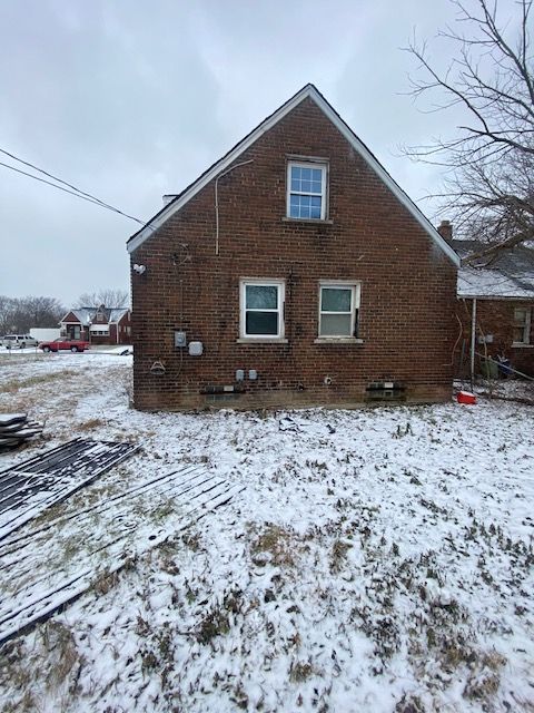 view of snow covered rear of property