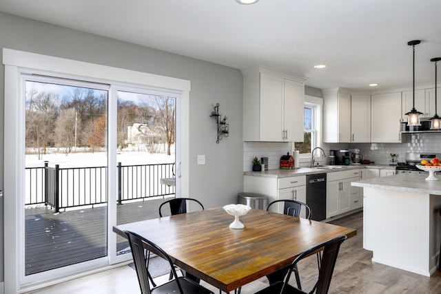 kitchen with white cabinetry, backsplash, black dishwasher, stainless steel range, and decorative light fixtures