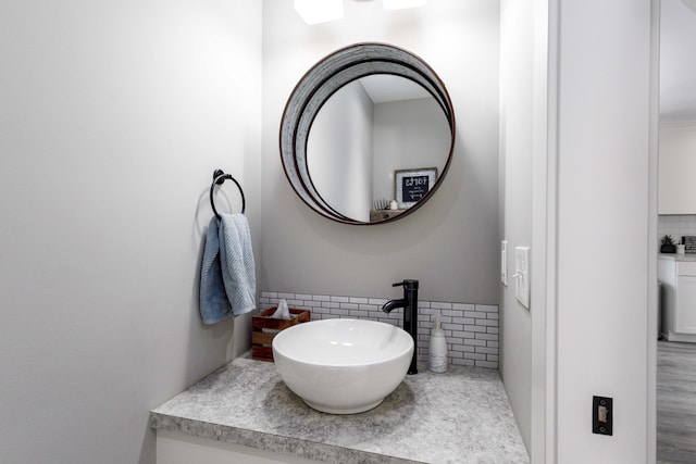 bathroom featuring vanity and decorative backsplash