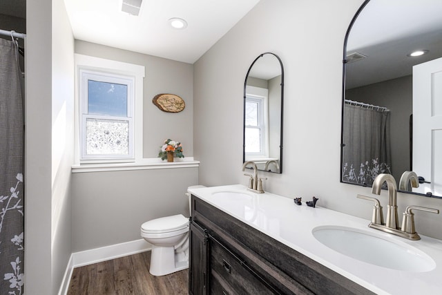 bathroom featuring wood-type flooring, vanity, and toilet