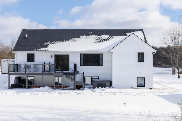 snow covered house with a wooden deck