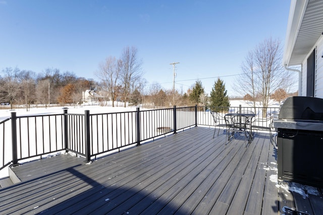 snow covered deck with a grill