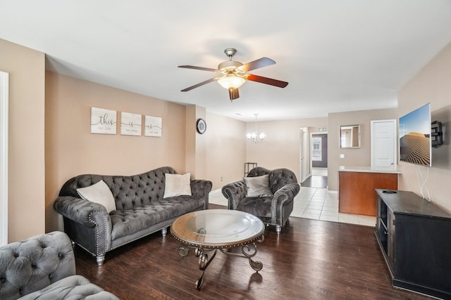 living area with ceiling fan with notable chandelier and light wood-style floors