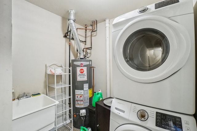 clothes washing area with gas water heater, a sink, stacked washing maching and dryer, and laundry area