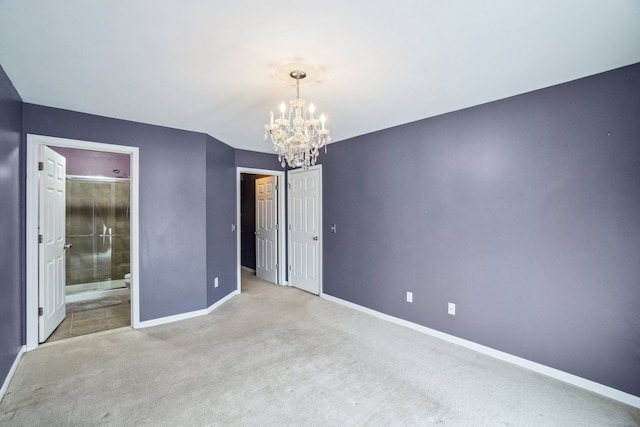 unfurnished bedroom with ensuite bath, baseboards, a chandelier, and light colored carpet