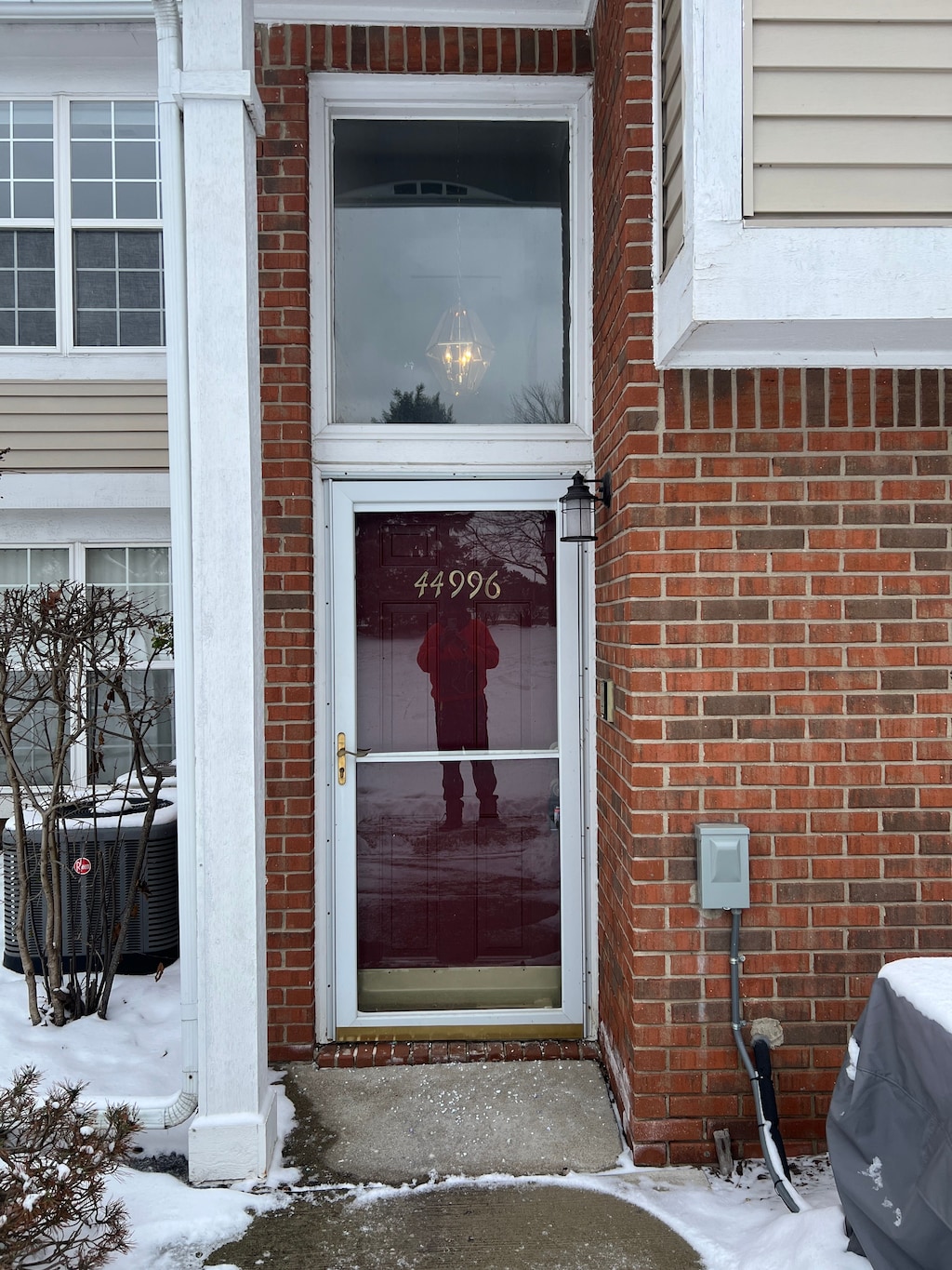 snow covered property entrance with central air condition unit