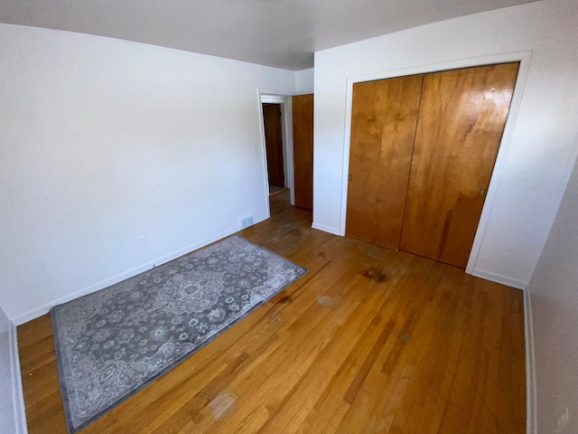 unfurnished bedroom with hardwood / wood-style flooring and a closet