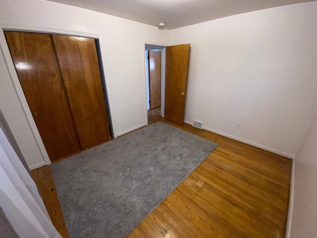 unfurnished bedroom with hardwood / wood-style flooring and a closet