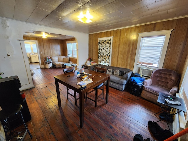 living room with cooling unit, wood-type flooring, and wooden walls