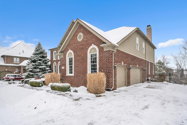 snow covered property featuring a garage