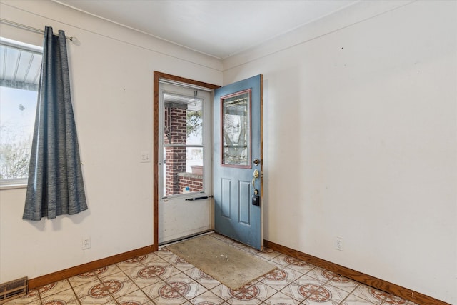 foyer featuring crown molding and a healthy amount of sunlight