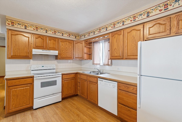 kitchen with sink, white appliances, and light hardwood / wood-style floors