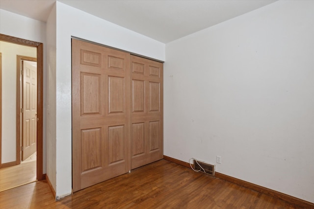 unfurnished bedroom featuring hardwood / wood-style floors and a closet