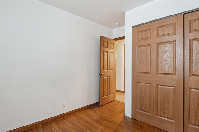 unfurnished bedroom with wood-type flooring and a closet