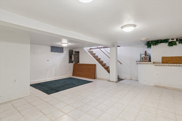 basement featuring electric panel and a textured ceiling