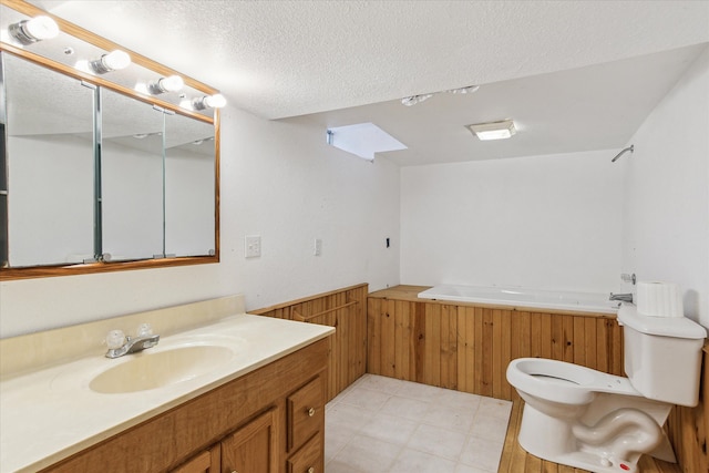 bathroom with a tub to relax in, toilet, a textured ceiling, vanity, and wooden walls