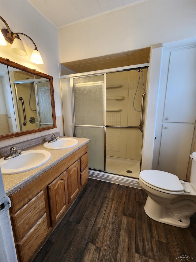 bathroom featuring toilet, vanity, a shower with door, hardwood / wood-style flooring, and backsplash