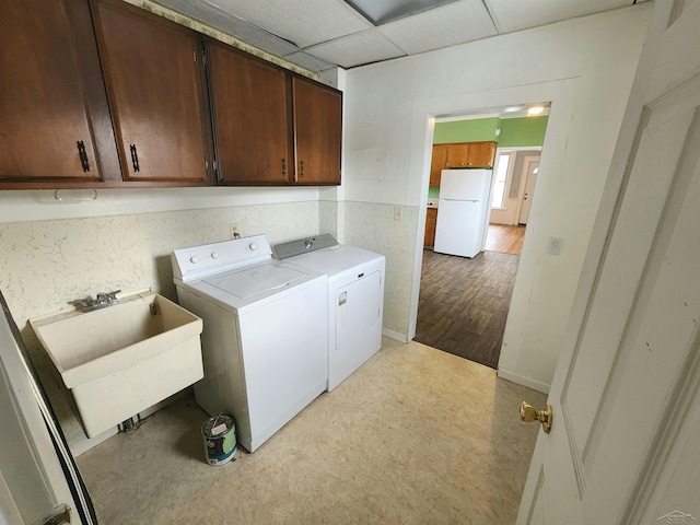 laundry area featuring sink, washing machine and dryer, and cabinets