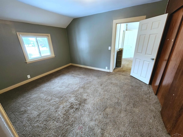 unfurnished bedroom with lofted ceiling and carpet