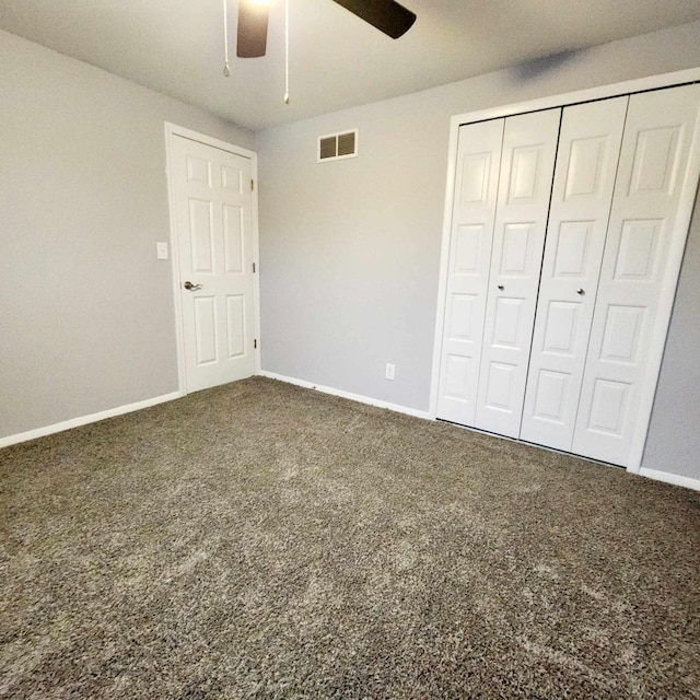 unfurnished bedroom with dark carpet, a closet, and ceiling fan