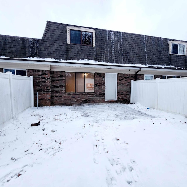 view of snow covered rear of property