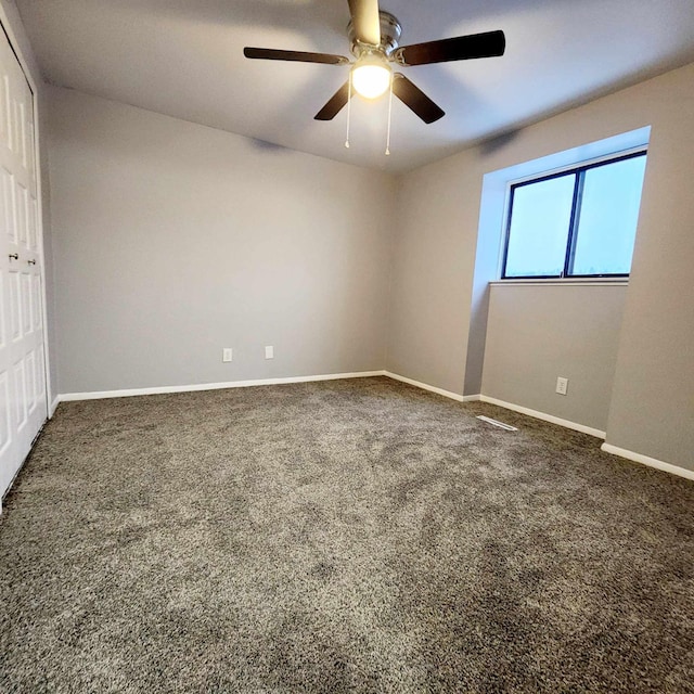 carpeted spare room featuring ceiling fan