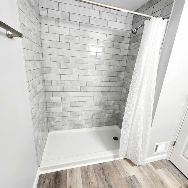 bathroom featuring curtained shower and wood-type flooring