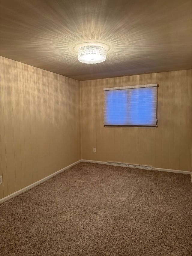 spare room featuring a baseboard heating unit and carpet flooring