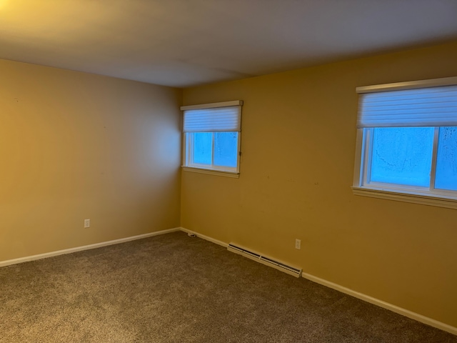 spare room featuring carpet and a baseboard heating unit