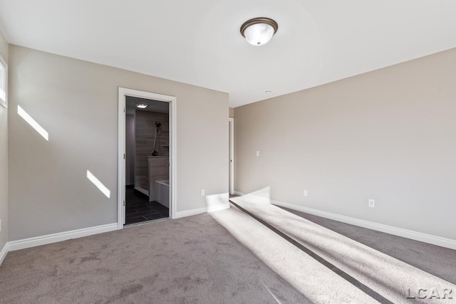 unfurnished bedroom featuring connected bathroom and carpet