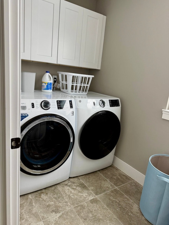 washroom featuring washing machine and dryer and cabinets