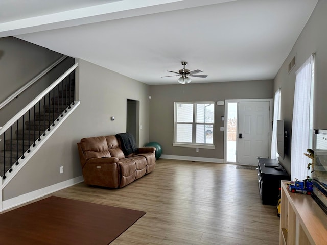 living room featuring ceiling fan and light hardwood / wood-style flooring