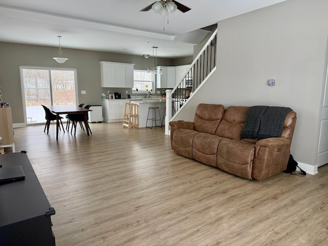 living room featuring ceiling fan and light hardwood / wood-style flooring