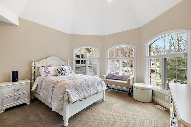 bedroom featuring high vaulted ceiling, baseboards, visible vents, and dark colored carpet