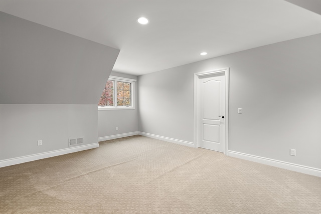 additional living space featuring lofted ceiling and carpet floors