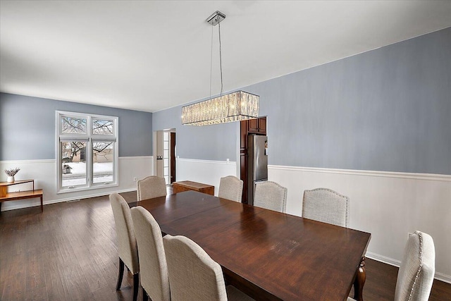 dining room featuring a notable chandelier and dark wood-type flooring