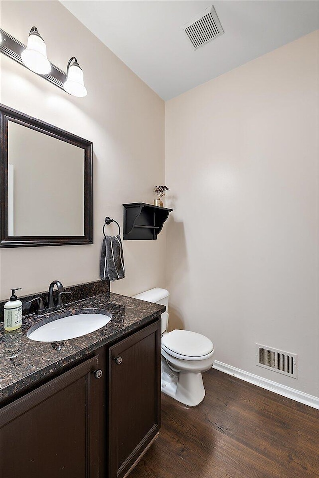 bathroom with vanity, hardwood / wood-style floors, and toilet