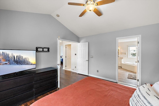 bedroom featuring ceiling fan, dark hardwood / wood-style flooring, vaulted ceiling, and ensuite bath