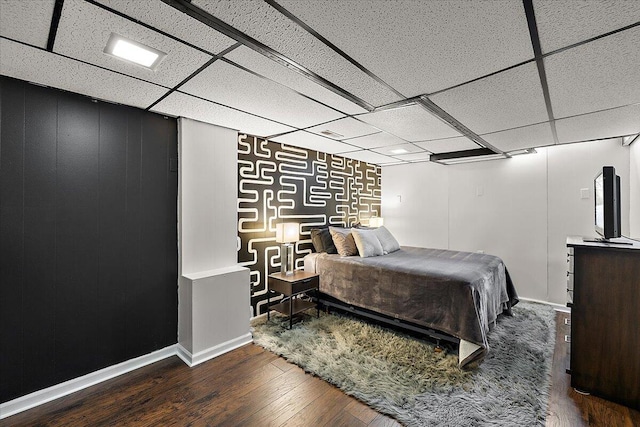 bedroom featuring hardwood / wood-style floors and a drop ceiling