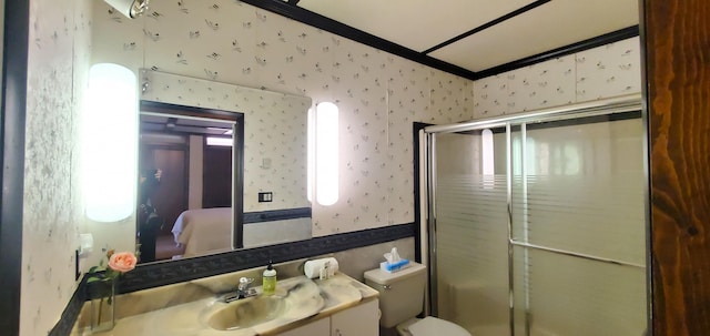 bathroom featuring vanity, toilet, and a shower with shower door